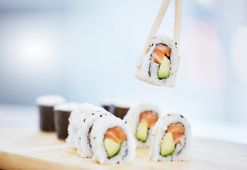 Image showing Sushi, closeup and food with fish for eating, salmon and rice with avocado, healthy and fine dining. Japanese cuisine, catering with lunch or dinner meal, chopsticks and gourmet seafood for nutrition