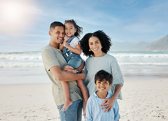 Image showing Mom, dad and children in portrait, ocean and happy with hug, love and bonding on vacation in summer sunshine. Parents, kids and smile together at beach, holiday and outdoor by sea, waves and sand