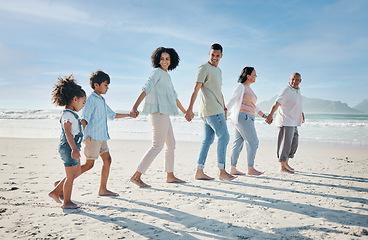 Image showing Walking, holding hands and family outdoor on a beach with love, care and happiness on travel vacation. Parents, grandparents or men and women with children at sea for holiday, journey or adventure