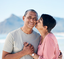 Image showing Kiss, love and mature couple outdoor at beach with a smile, care and happiness together in nature. Portrait of a happy man and woman for healthy marriage, kindness and anniversary on a travel holiday