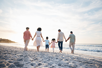 Image showing Holding hands, walking and back of big family at the beach for travel, vacation and adventure in nature. Love, freedom and rear view of children with parents and grandparent at sea for ocean journey