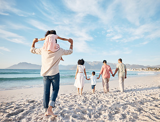 Image showing Big family, holiday and walking on beach, holding hands and piggy back on summer island sand from behind. Parents, grandparents and kids adventure on tropical vacation together at ocean in Hawaii.