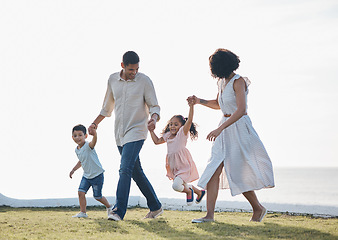 Image showing Happy family, holding hands and outdoor at a park with a love, care and happiness together in nature. Young man and woman or parents with children for walk, travel and playing on holiday or vacation