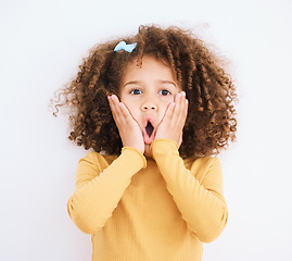 Image showing Child, shock and hands on face in studio for wow, surprise or announcement for sale or promotion. Face portrait of a young girl isolated on a white background with mouth open, news and omg emoji