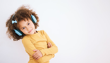 Image showing Portrait, music headphones and kid arms crossed in studio isolated on a white background mockup space. Face, confidence and girl child on radio listening to podcast, streaming audio and hearing sound