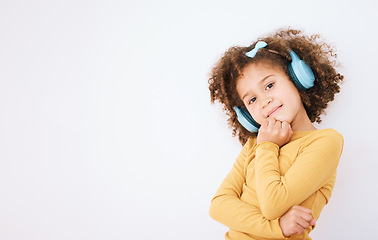Image showing Girl child, portrait and headphones and listening to music with smile isolated on white background. Technology, audio streaming and podcast, mockup space and kid with playlist and radio in studio
