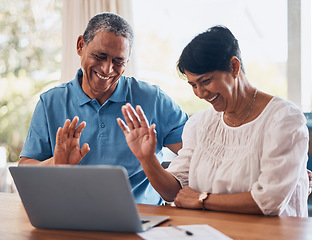 Image showing Video call, wave and senior couple with laptop in a dining room together for communication. Happy, smile and elderly man and woman in retirement greeting for virtual conversation on computer at home.