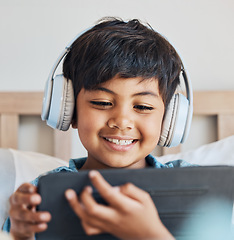 Image showing Face of kid, headphones and tablet in home for reading ebook, watch movies and play video game on elearning app. Happy boy child, digital tech and listening to multimedia, music and streaming cartoon