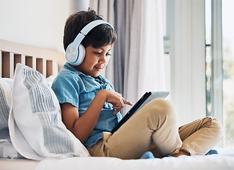 Image showing Boy, kid and headphones with tablet on bed for online games, watching movies or play educational app. Happy child, digital technology or listening to multimedia, music or streaming cartoon in bedroom