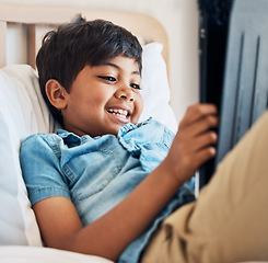 Image showing Happy, cartoon and a child with a tablet in the bedroom for movie, film or streaming games. Smile, relax and a boy kid with technology in a house for the internet, online reading or playing on an app