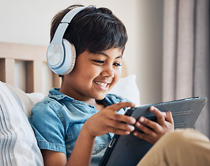 Image showing Happy, kid and headphones with tablet in bedroom to watch movies, video game and elearning app. Boy child smile with digital technology for multimedia, listening to music or streaming cartoon at home