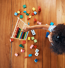 Image showing Above, child and toys for math on the floor, home education and fun activity. House, young and a girl kid with blocks and abacus for recreation, counting or perspective on the ground in childhood