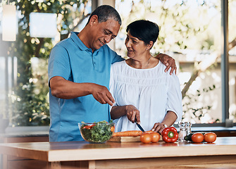 Image showing Happy couple, love and hug while cooking food, cutting carrot and prepare vegetables for salad at home. Mature man, smile and embrace woman in kitchen to make healthy lunch, meal and diet for dinner