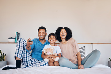 Image showing Smile, morning and a family watching tv on bed in their home together for streaming or entertainment. Parents, children or a boy in the bedroom with his mother and father to enjoy a television movie