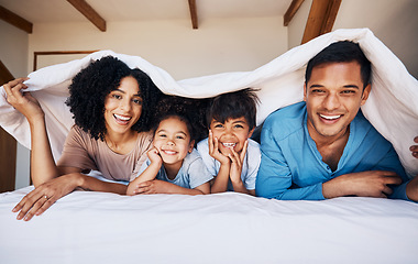 Image showing Happy, smile and portrait of a family with a blanket for relaxing, bonding or resting together. Happiness, love and young children with their parents from Colombia on the bed in room of their house.