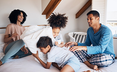 Image showing Happy family, parents and children on bed, pillow fight and relax together on weekend morning with fun. Mom, dad and kids in bedroom, playing and bonding in home with love, care and playful games.