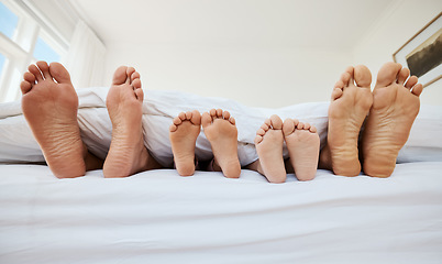 Image showing Family, feet and sleeping in bed in home, relax in peace and rest in morning blanket together. Barefoot, bedroom and father, mother and children with parents in comfort, bonding and care in house