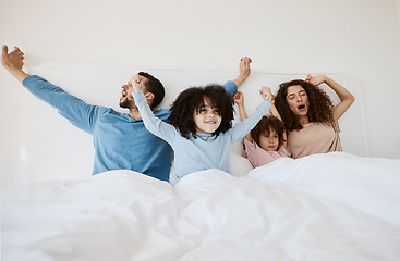Image showing Family, bed and yawn in morning wake up, relax or sleep together with arms up at home. Calm parents, children and bonding on holiday break, weekend or new day in peace, support or comfort in bedroom