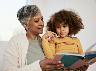Image showing Home, grandmother and young child reading book, cartoon comic and bonding with senior woman in lounge. Learning, youth development education or grandma storytelling fairytale fantasy to listening kid