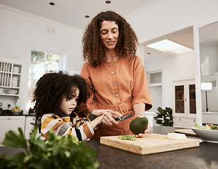 Image showing Food, avocado and a mother cooking with her daughter in the kitchen of their home together for nutrition. Family, health or diet with a woman teaching her child about eating green vegetables