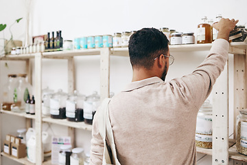Image showing Customer, back and shopping by shelf in grocery store for healthy food, nutrition and wellness product sales. Choice, decision and nutritionist man in supermarket for retail purchase, buying or deal