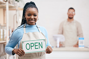 Image showing Open, sign or black woman with small business or restaurant happy for service in coffee shop, cafe or store with board. Smile, manager and portrait of entrepreneur ready for operations with billboard