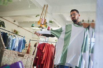 Image showing Mirror reflection, shopping and a man with choice of clothes in a store. Weekend, check and a person with a shirt in a boutique with a decision in clothing, apparel or an outfit at a shop for style