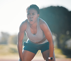 Image showing Break, tired and a black woman at a stadium for a workout, training or breathing after cardio. Sports, race and an athlete or African runner with an idea for fitness, running or exercise on a track