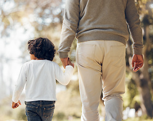 Image showing Back, holding hands or kid with a grandfather in park for walking or bonding together family care. Parent, kindness or senior man with a child for support, trust or loyalty in nature garden for love