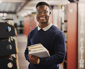 Image showing Student, university and portrait of black man in library for learning, education and reading books. Academy, college and happy African person with textbooks for research, school project and studying