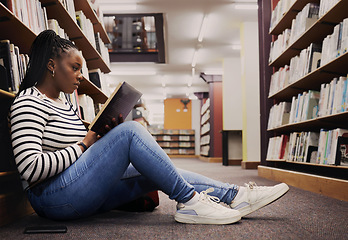 Image showing Research, book and a black woman in a library for reading, college knowledge or studying on the floor. Scholarship, student and an African girl at a university or a bookshop for education or learning