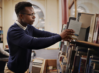 Image showing University, research and man in a library reading and learning on campus for knowledge and education in college. Smart, clever and young person in an academy with books on a shelf for an exam