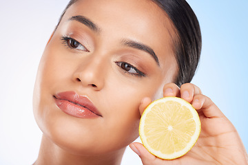 Image showing Beauty, lemon and face of studio woman with citrus fruit for organic anti aging treatment, facial detox or aesthetic cosmetics. Vitamin C benefits, spa wellness and self care model on blue background