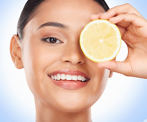 Image showing Beauty skincare, portrait and happy woman with lemon for citrus detox treatment, natural self care or wellness. Vitamin C food, fruit product and studio face of dermatology person on blue background