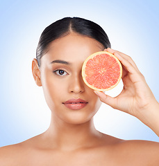 Image showing Beauty skincare, portrait and woman with grapefruit for organic collagen treatment, natural self care or fruit benefits. Vitamin C, citrus product or studio face of wellness person on blue background