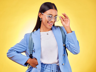 Image showing Fashion, student or portrait of woman in sunglasses on yellow background with trendy clothes or smile. Girl, happy person and excited gen z model with cool style, bag or elegant outfit in studio