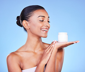 Image showing Skincare, cream and product with woman and jar in studio for beauty, facial or moisturizer. Spa treatment, health and collagen with face of person on blue background for makeup, glow or sunscreen