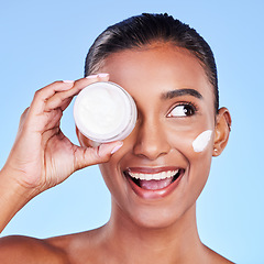 Image showing Skincare, cream and product with woman and moisturizer in studio for beauty, facial or lotion. Spa treatment, health and collagen with face of person on blue background for makeup, glow or sunscreen