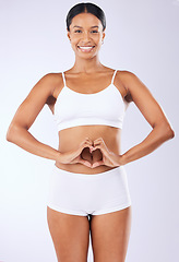 Image showing Heart, woman and hands on stomach in underwear for wellness, diet and gut health in studio on white background. Person, smile and portrait of body for abdomen, detox, colon and transformation