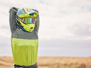 Image showing Sports, stretching and man with helmet in nature for training, workout and performance. Travel, mockup space and person outdoors for motor cycling for adventure, freedom and adrenaline in desert