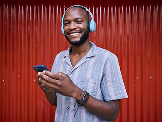 Image showing Black man, phone and headphones, smile with technology and media for podcast, music and online streaming. Happy, person and smartphone with radio app for listening to audio, sound and multimedia