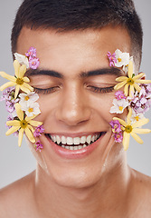 Image showing Relax, face or happy man with flowers for beauty, natural cosmetics or wellness in studio on white background. Nature aesthetic, smile or model laughing at eco friendly skincare or spring floral art