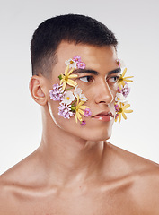 Image showing Thinking, creative and a man with flowers on a studio background for ecology or nature aesthetic. Floral, serious and a male model with plants for facial cosmetics, skincare or an idea on a backdrop