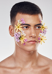 Image showing Thinking, beauty and a man with flowers on a studio background for ecology or nature aesthetic. Creative, serious and a male model with plants for facial cosmetics, skincare or an idea on a backdrop