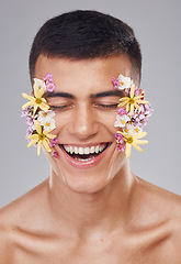 Image showing Skincare, man and flowers on face in studio, eyes closed and natural cosmetics for art, makeup product and wellness. Spring, person and closeup of floral decoration for facial on gray background
