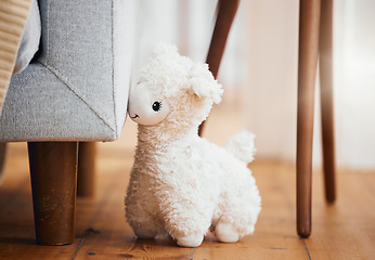 Image showing Teddy bear, empty room and toy on floor of home, background and alone by sofa in lounge of house. Abandoned, lonely and stuffed animal for grief, mental health, loss and sad or security by couch