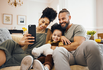 Image showing Interracial parents, child and selfie on sofa, smile and hug for love, bonding and memory on web blog. Mom, dad and kid for photography, profile picture and happy for social media app in family house