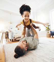 Image showing Father, child and airplane game on floor, playing and excited with care, love and lift in air, living room or house. Dad, kid and playful with plane, flying and bonding in interracial family home