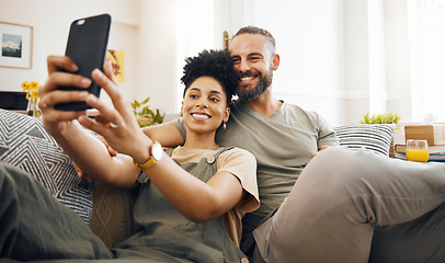 Image showing Interracial couple, selfie and happy on couch, relax at home with social media, streaming and memory with commitment. Smile in picture, post and love, care and trust, people in lounge with romance