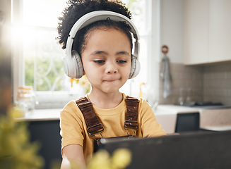 Image showing Tablet, headphones and kid in online education in home, elearning or homeschool in kitchen. Serious, technology and boy child on video call, study on internet and listening to music in virtual class